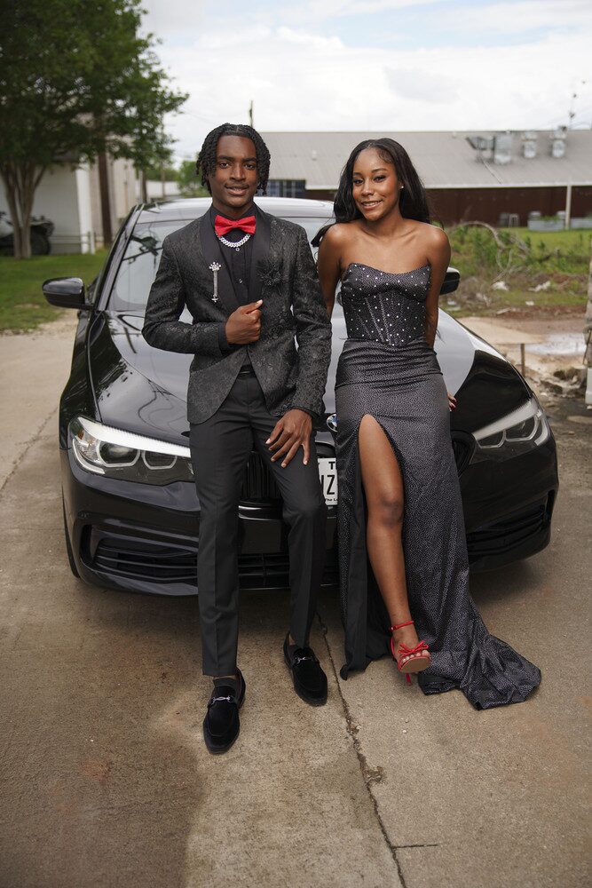 Jalen Jackson and his prom date seated in front of a car